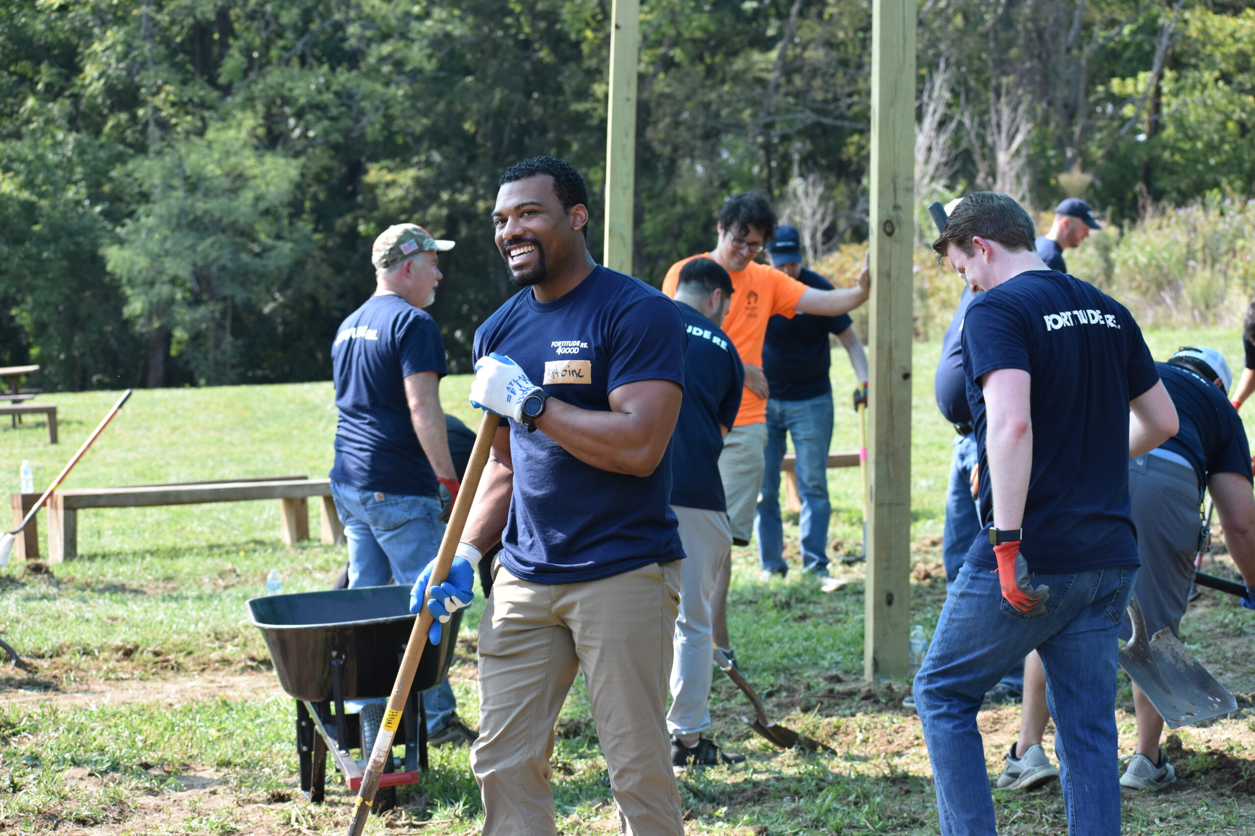 A man holds a rake while volunteering.