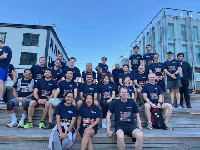 More than twenty colleagues sitting in athletic clothes before a race.